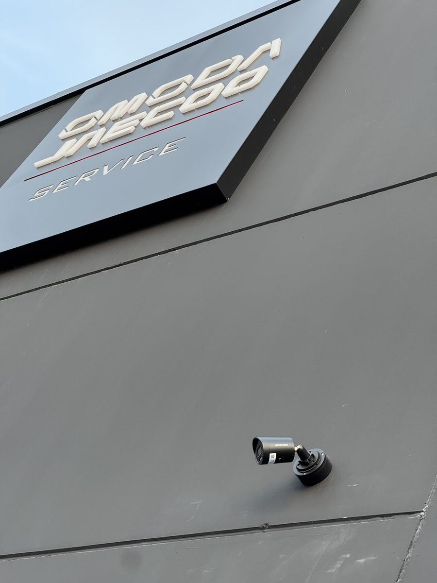 Cámara exterior en acabado negro sobre la fachada del área Service
