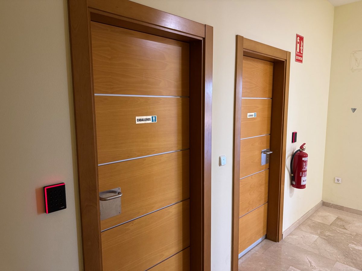 Lector de tarjetas junto a una puerta del pasillo de oficinas