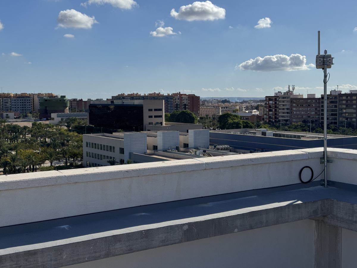 Mástil con gateway en la esquina de una cubierta, con el campus y la ciudad al fondo