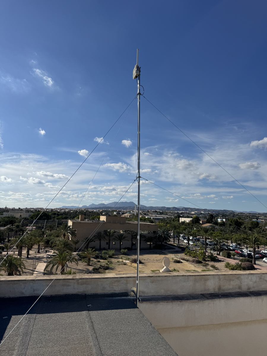 Mástil con gateway LoRaWAN y vientos sobre la cubierta de un edificio del campus de la Universidad Miguel Hernández de Elche