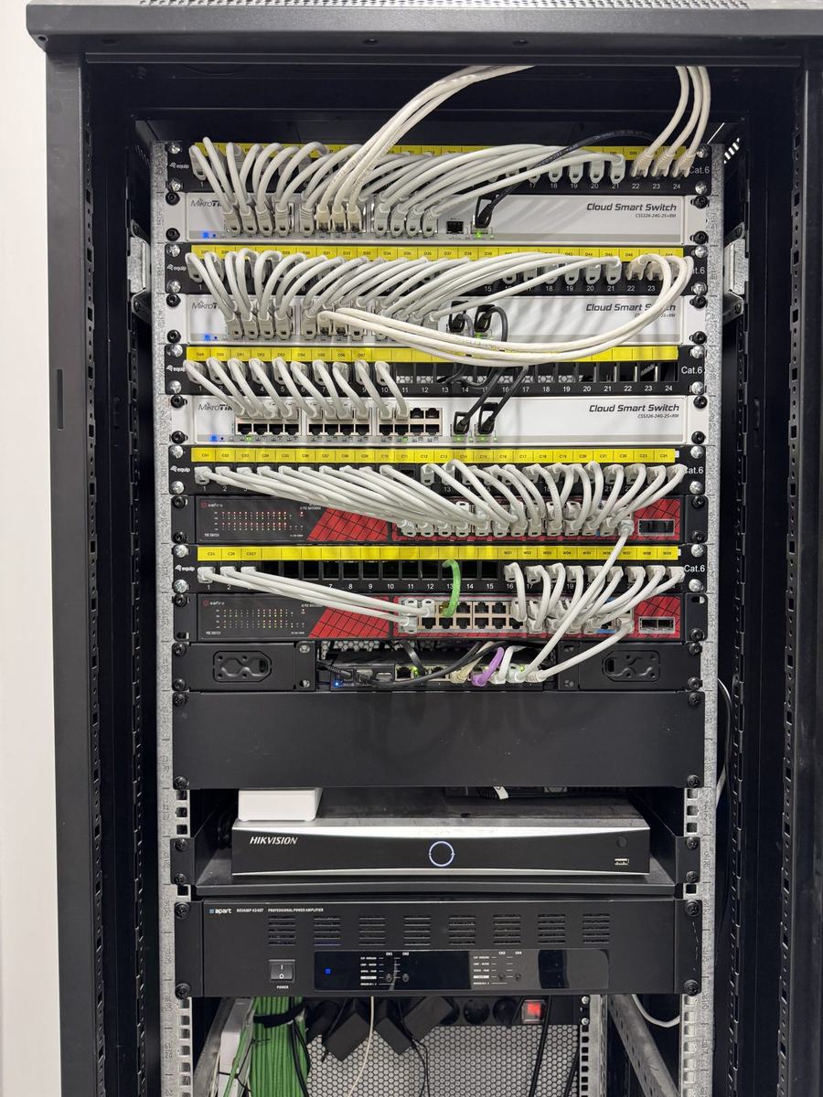 Patch panels Cat.6 etiquetados y switches MikroTik en el rack