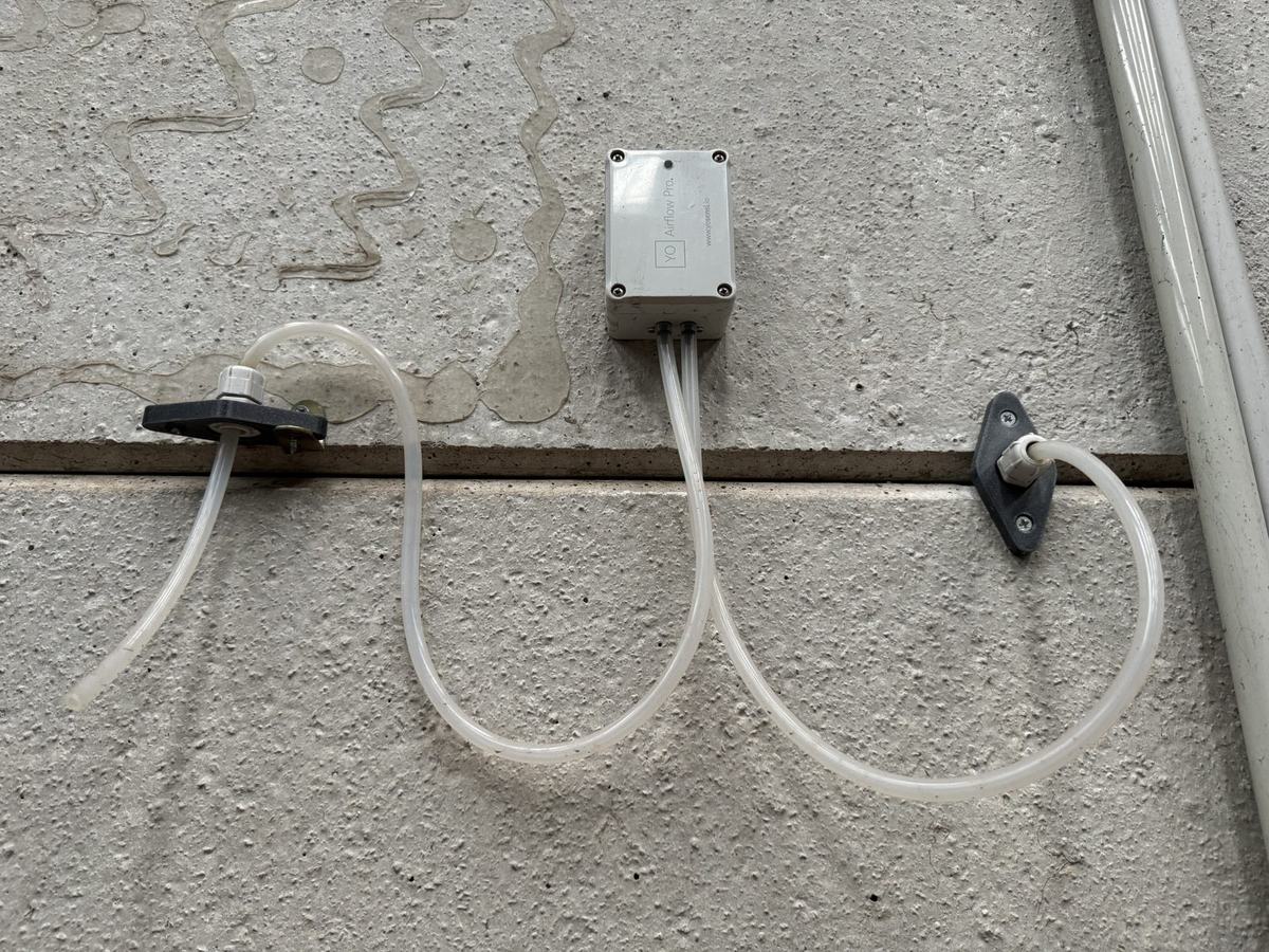 Sensor de presión diferencial instalado por BAIOT, con tomas a ambos lados de un muro